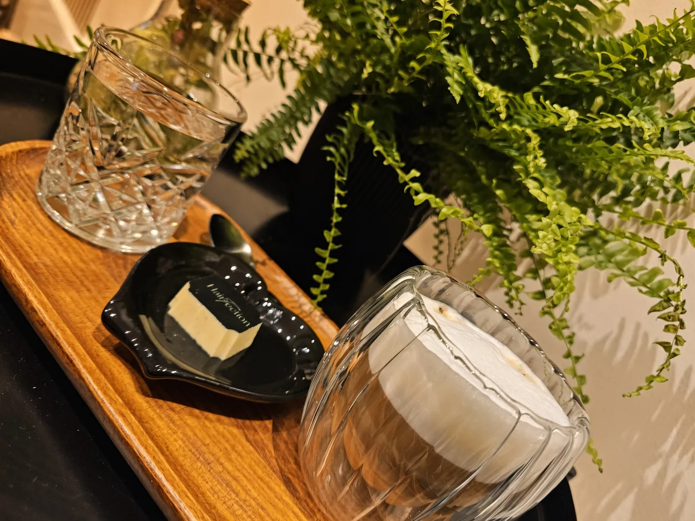 Koffie, water en Hairfection-chocolade op een houten dienblad